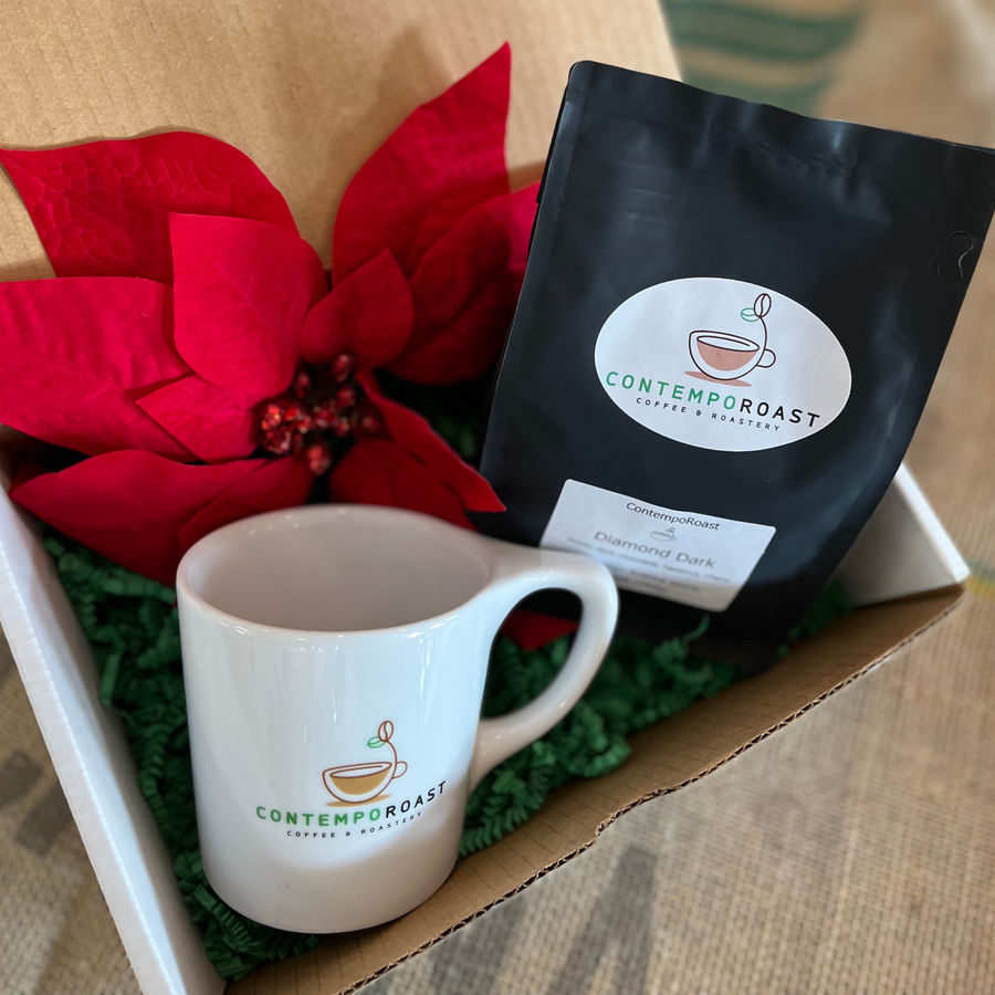 A 16oz branded porcelain notNeutral Lino mug and a 12oz bag of coffee in a gift box with crinkly green paper (also shown, poinsettia, not included)