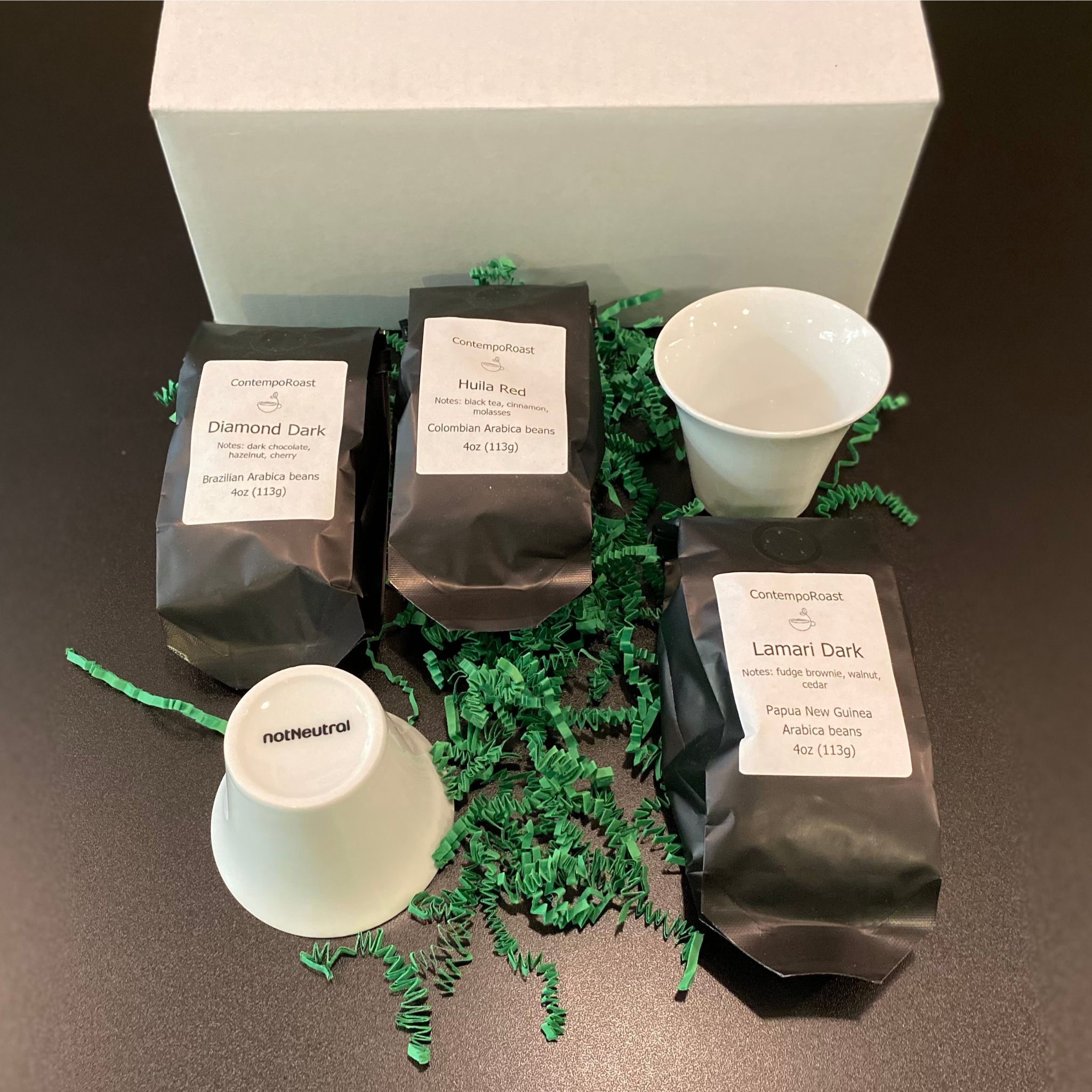 Our lighter set: 2 notNeutral Cala 3-oz tasting cups with a 4-oz bag each of Esmeralda, Haitian Blue and Tropical Tolima whole-bean coffee bags; shown outside the gift box