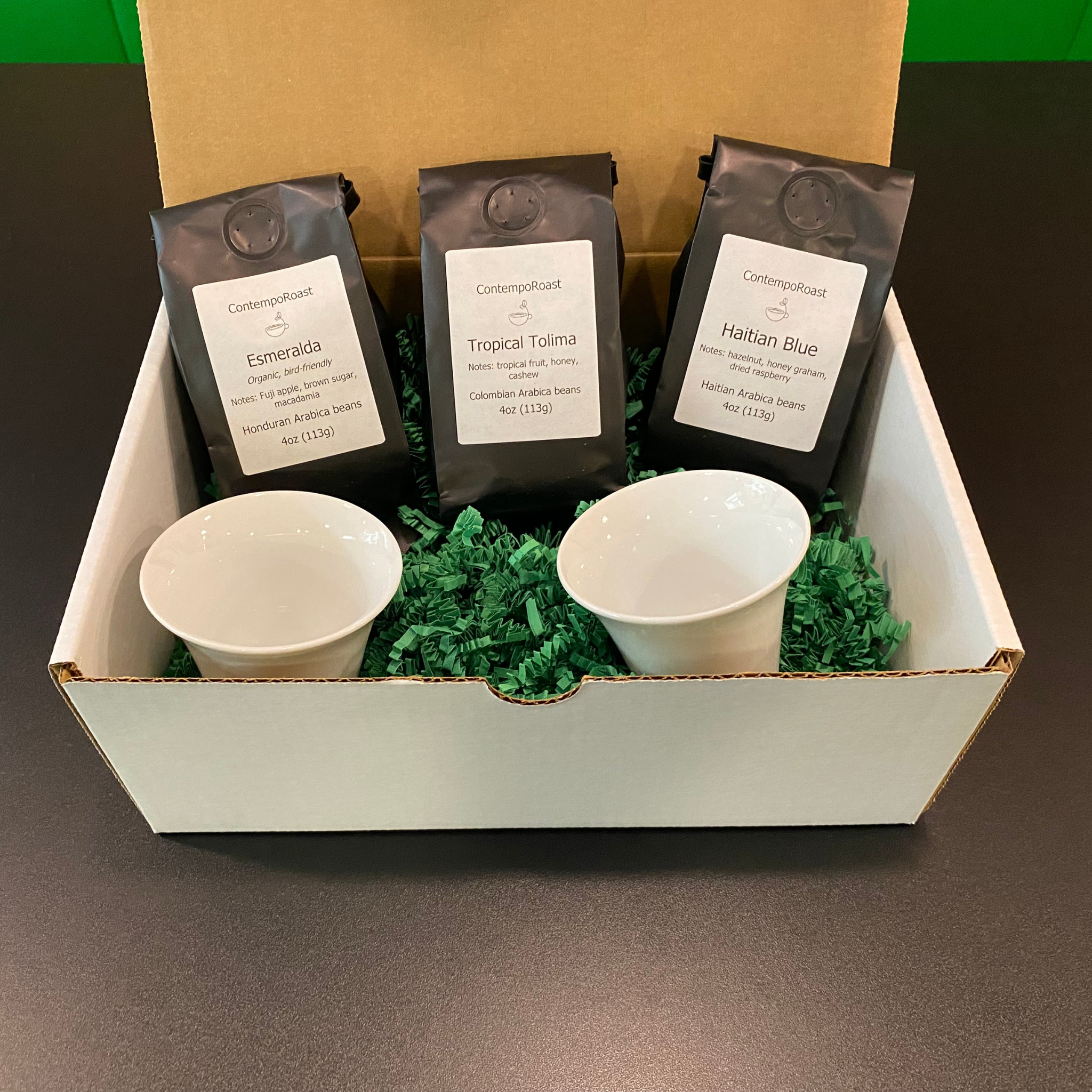 Our lighter set: 2 notNeutral Cala 3-oz tasting cups with a 4-oz bag each of Esmeralda, Haitian Blue and Tropical Tolima whole-bean coffee bags; shown in a gift box