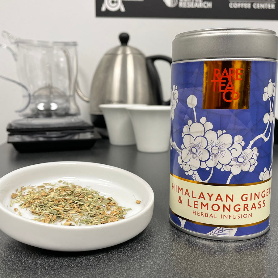 Photo of lemongrass with pieces of dried ginger and tin that says Rare Tea Co, Himalayan Ginger & Lemongrass herbal infusion