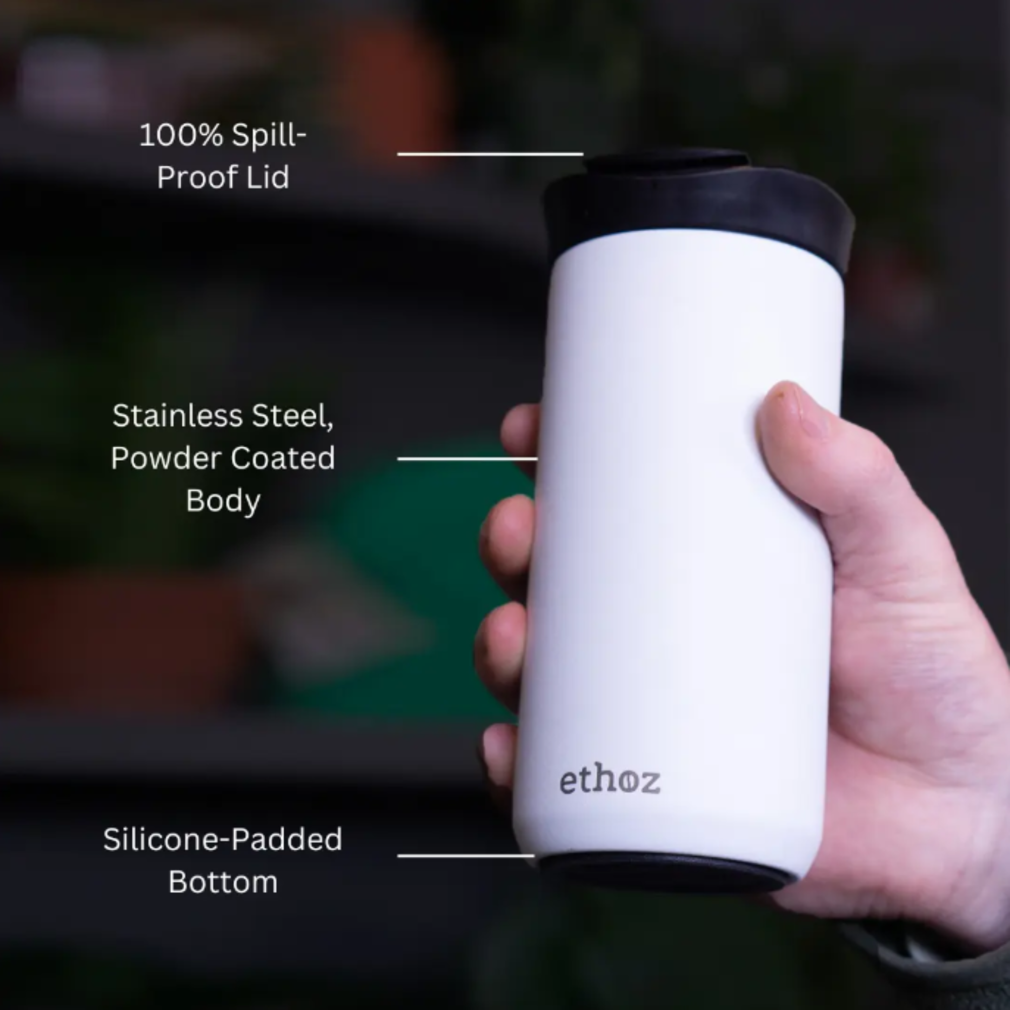 white travel mug showing 100% spill-proof lid, stainless steel, powder-coated body, and silicone-padded bottom